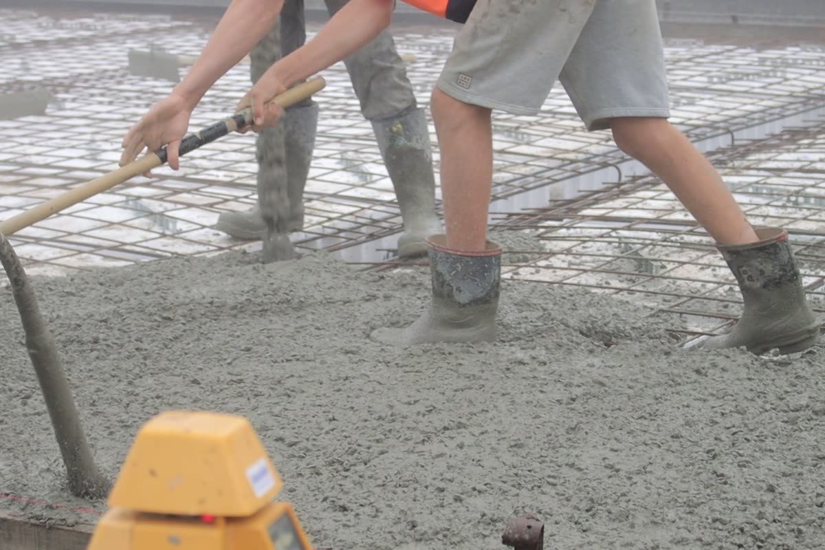 Concrete being poured and spread into formwork